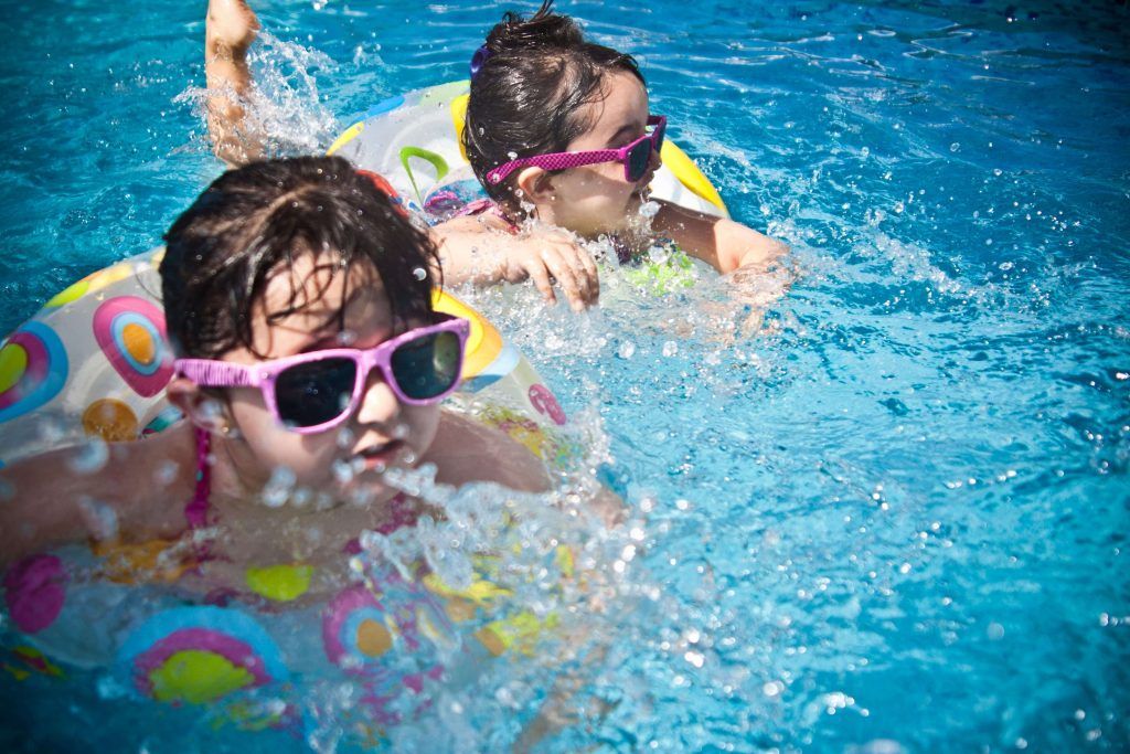 Image of two kids swimming in a pool , Sabbatella pool and spa , Pool Contractors Woodland Hills CA.