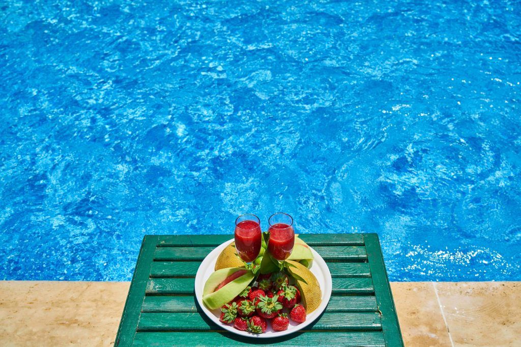 Image of a fruit plate on the table beside the swimming pool , Sabbatella pool and spa , Pool Contractors Woodland Hills CA.